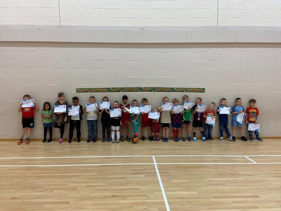 Children holding certificates after a Discover Sports party