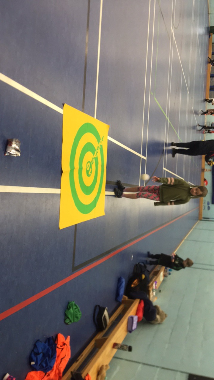 Child aiming at colourful target during indoor PE